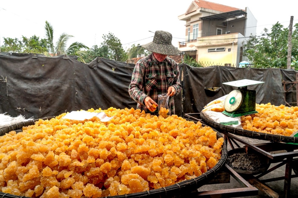 Fresh golden jaggery being weighed and packed